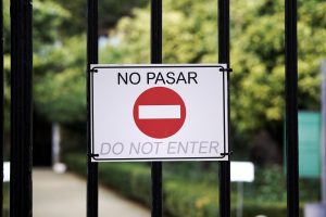 Do not enter sign on a fence, with text in English and Spanish