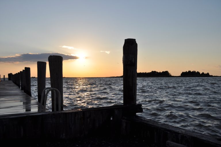 Silhouette of a pier at Crisfield, Maryland with setting sun in the background