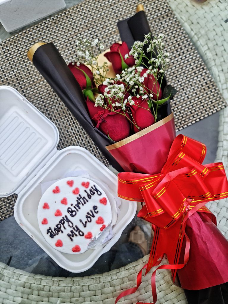 Birthday cake and red roses bouquet