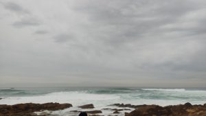 多云的天气，波涛很大，冲浪者在坎塔布里亚海冲浪。在“La vaca Gigante”活动上。
