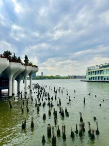 Broken pilons in the ocean with a view of buildings and a terrace