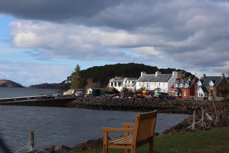 Bench on the shore of the Sheildaig sealoch, with Sheildaig village in the distance, Scottish Highlands