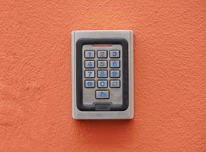 Aluminium numeric security key on an orange stucco wall