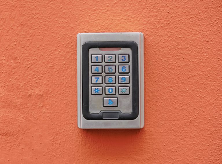 Aluminium numeric security key on an orange stucco wall