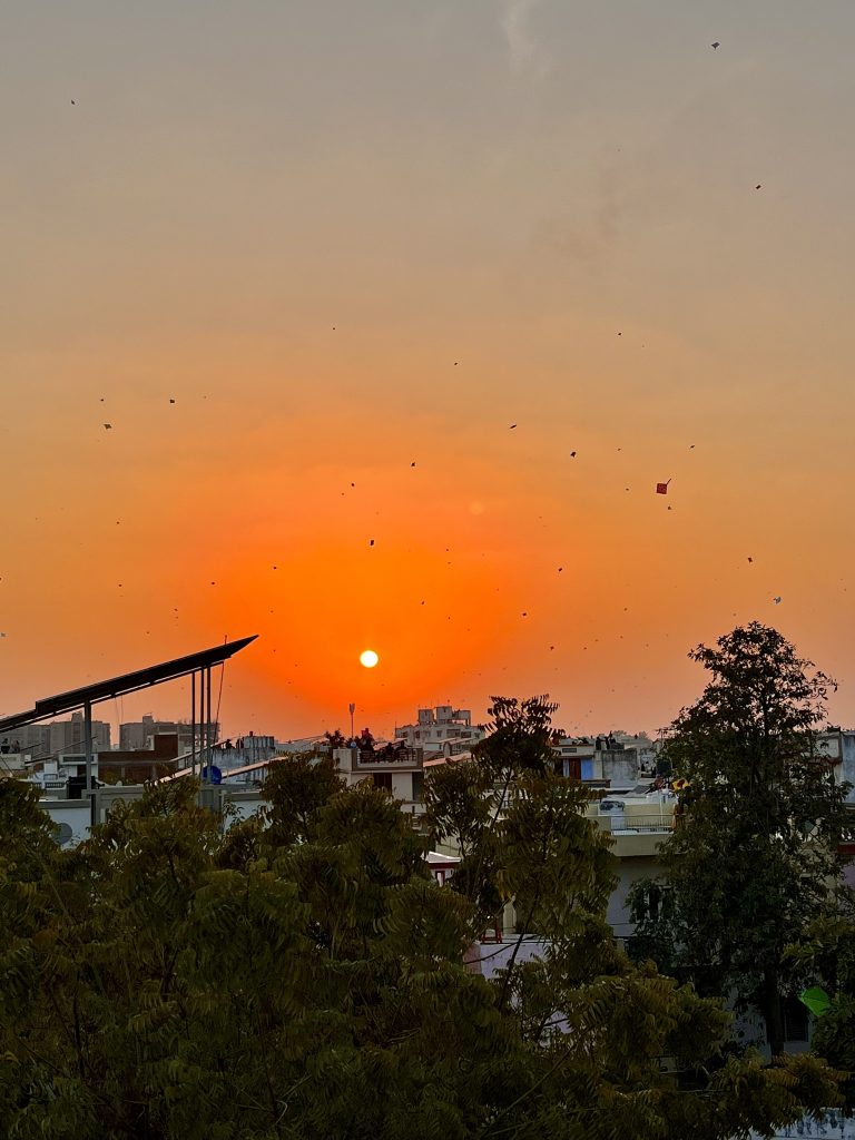 Kite Festival at Sunset, with kites in the sky over buildings