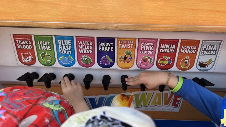 Kona Ice mobile snow cone truck showing various flavor dispensers