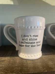 Ceramic coffee cup with the text “I don’t rise and shine I caffeinate and hope for the best”
