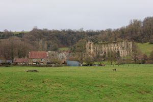 Rievaulx Abbey with a grey sky in the background.