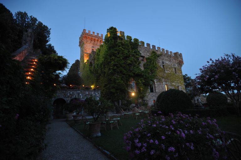 Castello di Vincigliata, Fiesole in Florence Italy. Taken at dusk, showing the castle as a whole from the outside courtyard. Stairs lit with candles, and showing a blooming garden.