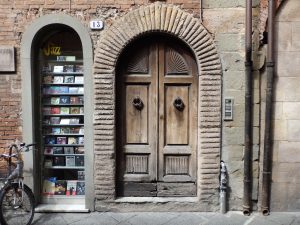 Wooden arched door by the side of a music shop window taken in Florence, Tuscany, Italy. 