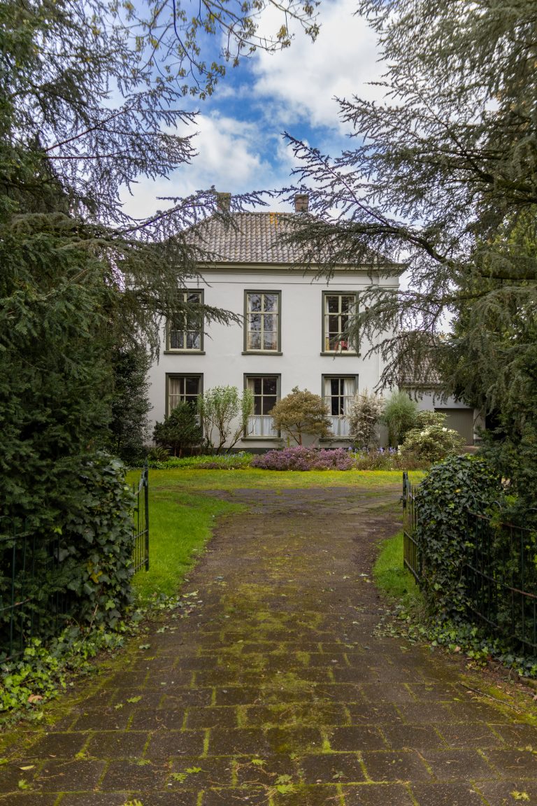 A driveway to a gate to a House. Traditional European architecture, often seen in the Netherlands.