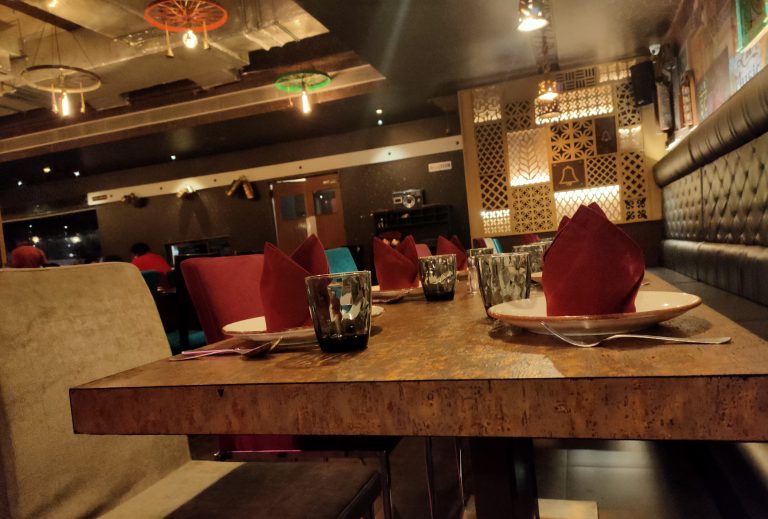 Interior of a restaurant with a table set up for customers with red napkins