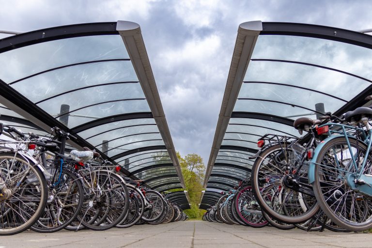 Bicycles parked at the station in Wijchen, the Netherlands, with a cloudy sky.