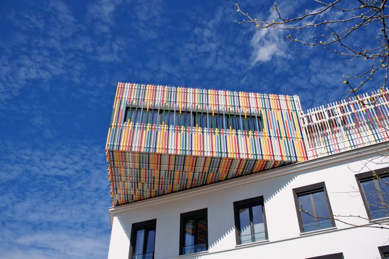 Building with colorful wood against a bright blue sky