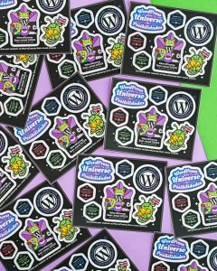 Composition of various Wapuu sticker sheets from WordCamp San José 2023 on a green and violet surface.
