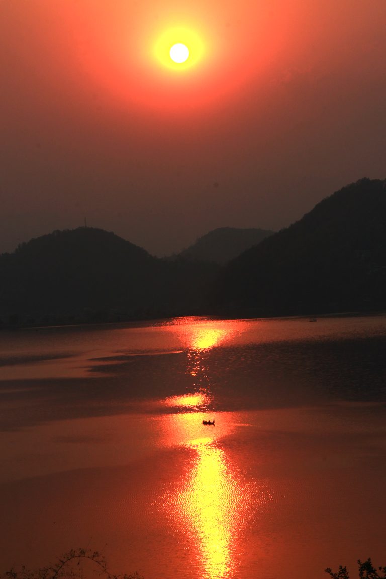 Sailing into the sunset, where the sky meets the water in a perfect alignment of light and shadow