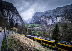 A train going through a charming Swiss mountain village.