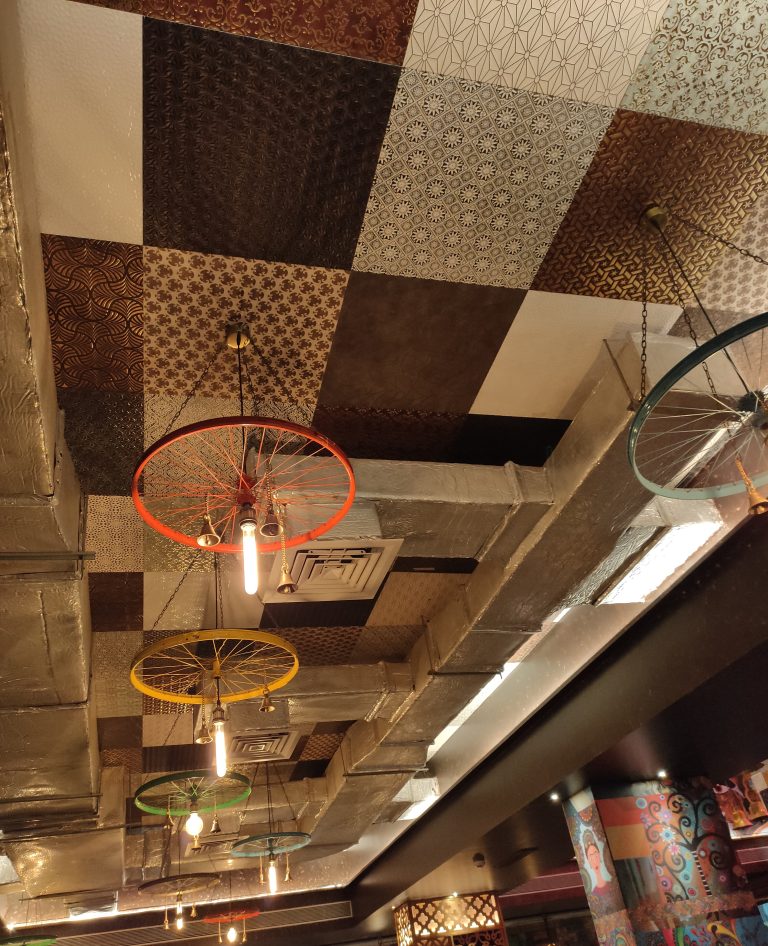 Roof decorated using bulbs and cycle wheel in restaurant