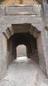 Close look of 3 door (tin darwaza) from outside, Panhalgad near Kolhapur India 
Message written by Mughal Empire in Urdu is visible above door.