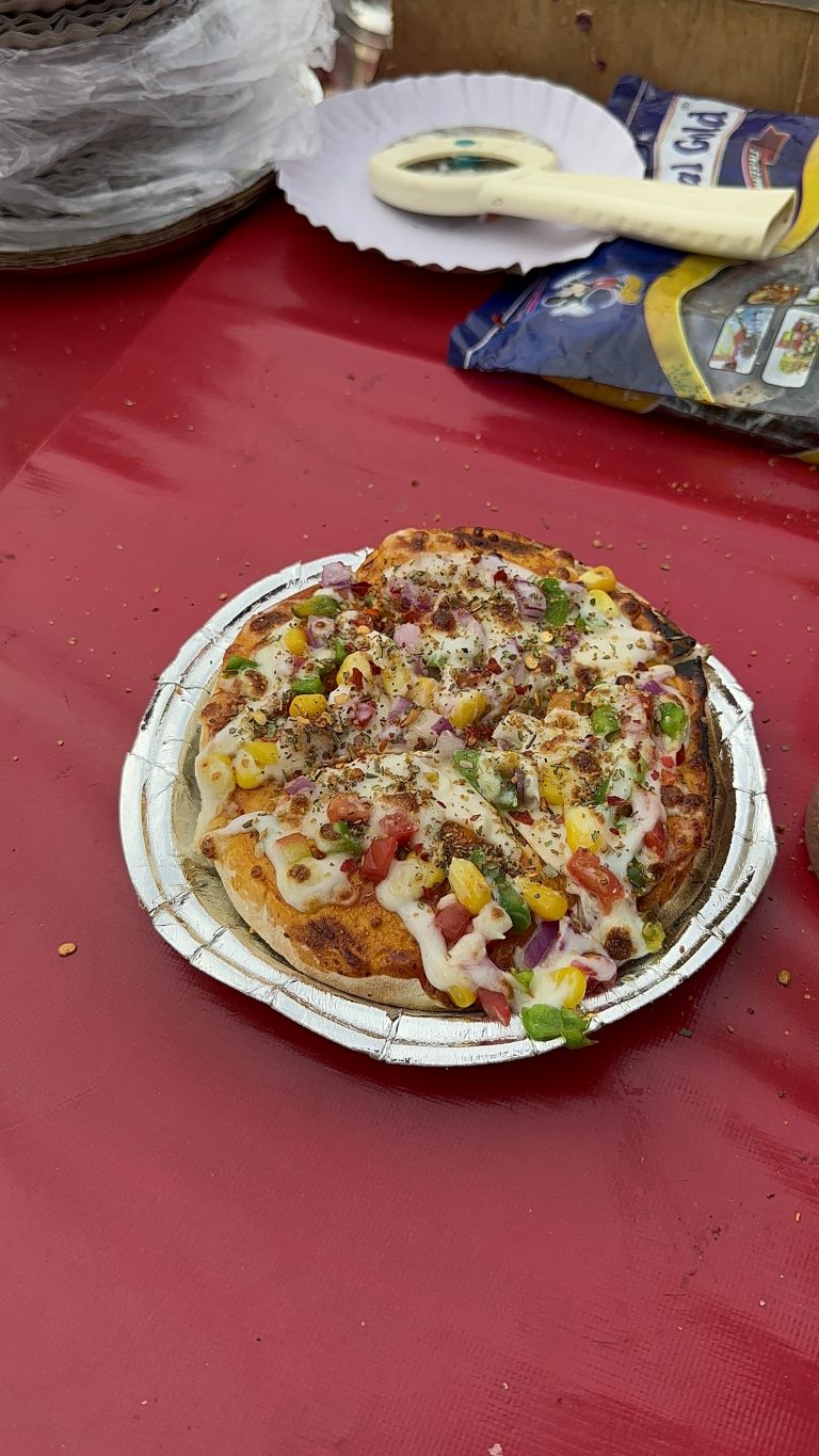 A small vegetarian pizza in a street food market India.