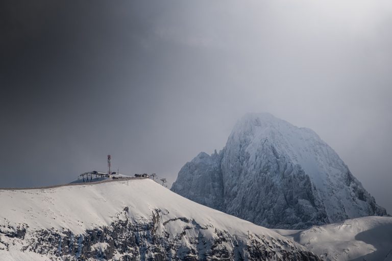 Au dessus des Deux Alpes. Snow covered mount partially hidden by fog.