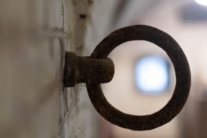 A metal ring on a wall in Fort Pannerden, The Netherlands, with an out of focus window seen through the ring