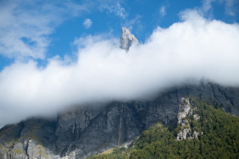 Welcome to Sixt. A mountain peaking above a layer of white clouds.