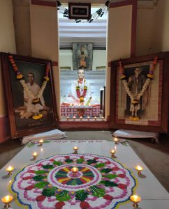 Rangoli design in front photos of Swami Swaroopanand in Temple