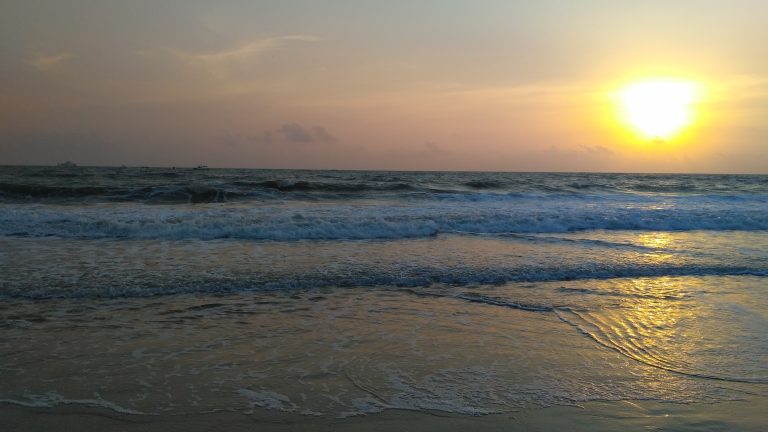 The sea’s relentless waves dance under the sun’s golden rays, a mesmerizing rhythm of nature’s symphony.