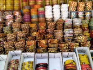 Colorful bangles stacked neatly on display in a shop, featuring various designs and vibrant hues.