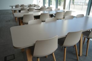Empty university dining hall with white tables and chairs