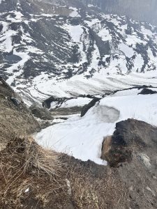 Hills covered with snow and a small pond with cold water. 