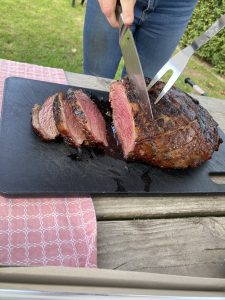 
Image of someone cutting BBQ Picanha steak on a wooden board.