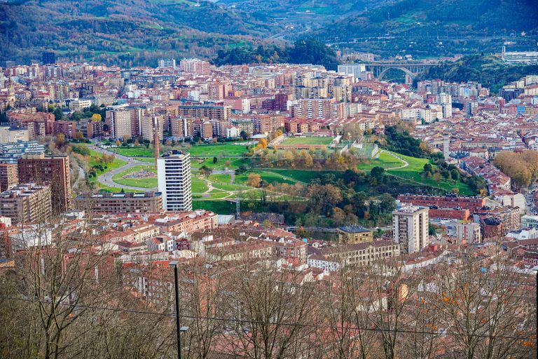 Aerial view of the city of Bilbao, with a big park in the middle and mountains at the back