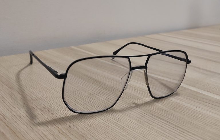 Black framed eye glass on a wooden surface