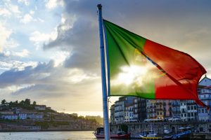 Portuguese flag waving over the coast of Douro river in Portugal