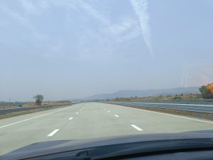 Empty highway with clear sky and faded mountains captured from the car
