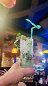 Holding mojito mock tail with mint at the top.
