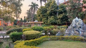 A serene garden with a statue at its center, located in Parmarth Niketan garden.