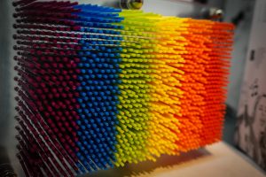 Desktop toy consisting of hundreds of rainbow-colored sticks