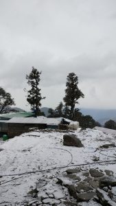  Snowfall on homes at chopta trek, Himalaya ranges visible behind