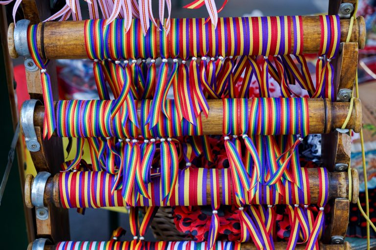 Colorful wristbands, some with the pride flag and others with the Spanish Republic flag.