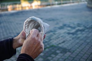 Hands of an artisan distributing clay inside a mold