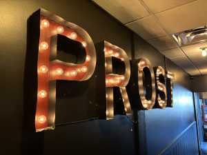 View larger photo: Sign that says Prost.  It's about 5 feet, 1.5 meters wide, with the letters hollowed out and filled with flowing lightbulbs.