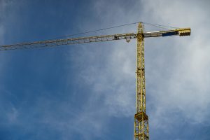 Big yellow constriction crane over a blue sky