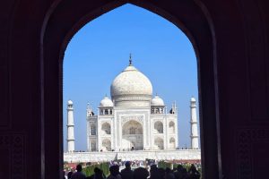 View of Taj mahal from a dark arch with a big crowd of tourists 