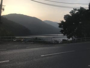 Silence road near the river and beautiful hills at the evening time.