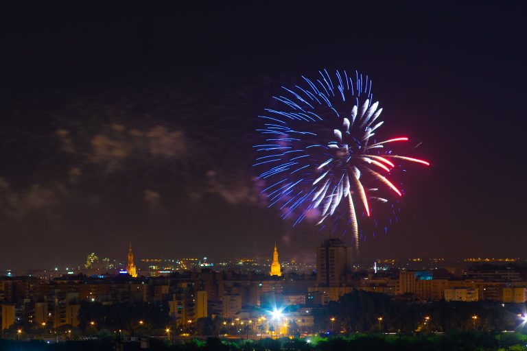 Red, blue and white fireworks over the city of Sevilla