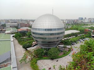 American International University at Bangladesh (AIUB). Sphere-shaped building surrounded by vegetation