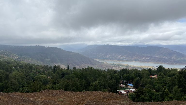 Cloudy atmosphere at a high point house with lush greenery and a scenic river view in the background